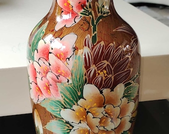 多色の花飾りと金色の仮面があしらわれたアジアの七宝焼きの大型花瓶