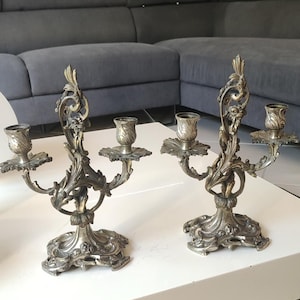 Pair of Louis XV/Rococo style bronze candelabra with a gilt patina, each with two lights, 19th century. Decorated with scrolling foliage/arabesques and floral motifs.