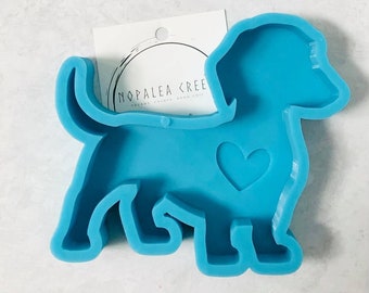 May include: A blue silicone mold shaped like a dachshund with a heart cutout. The mold is for making resin crafts.