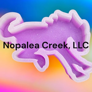 May include: A purple glitter resin mold of a horse with the text "Nopalea Creek, LLC" on the bottom.