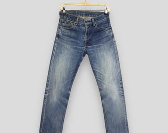 Calça jeans vintage Levi's 505, lavagem stone wash, com zíper, tamanho 27x28, anos 90. Jeans Levi's azul desbotado, corte reto. Modelo Levi's 505 feminino, tamanho Mom W27.