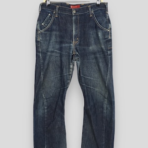 May include: A pair of dark blue denim jeans with a faded look. The jeans have a straight leg and a classic five-pocket design.