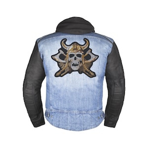 May include: A blue denim jacket with black leather sleeves and a large embroidered patch on the back. The patch features a skull wearing a horned helmet and crossed axes.