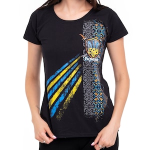 May include: Black t-shirt with a blue and yellow graphic design featuring the Ukrainian coat of arms and the word "Україна" (Ukraine) in Cyrillic script.