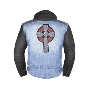 May include: A denim jacket with a black leather collar and sleeves. The back of the jacket features a large embroidered patch of a silver Celtic cross with a skull in the center. The cross is surrounded by a red and silver Celtic knot design.
