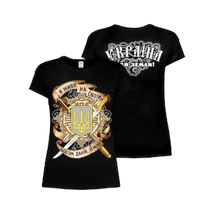 Puede incluir: Camiseta negra con un gráfico dorado y amarillo de un escudo de armas con un tridente, espadas y el texto "Я НИБУ НА СВОИ БОГОМ ДАНИ, ЗЕМЛИ!"