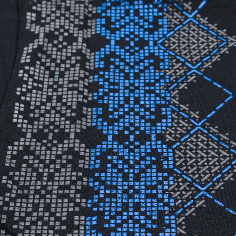 May include: Black fabric with a geometric pattern in shades of gray and blue. The pattern is made up of small squares and diamonds.