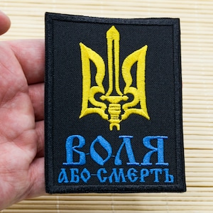 May include: A black patch with a yellow embroidered Ukrainian trident and the text "ВОЛЯ АБО СМЕРТЬ" in blue.
