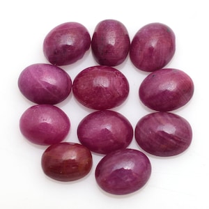 May include: Ten oval-shaped, pink gemstones with a smooth, polished finish. The gemstones are arranged in a circular pattern on a white background.