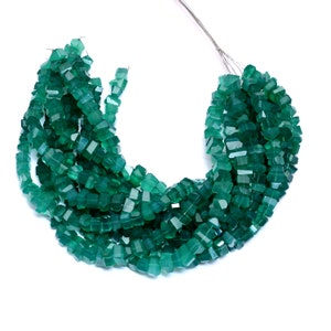 May include: A strand of dark green faceted gemstone beads. The beads are square shaped and have a polished finish.