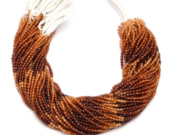 May include: A strand of brown and orange gemstone beads. The beads are faceted and have a graduated colour from light orange to dark brown.