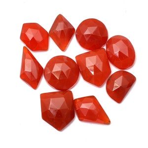 May include: Ten faceted carnelian gemstones in various shapes and sizes, including round, oval, and diamond shapes. The stones are a deep orange-red colour.