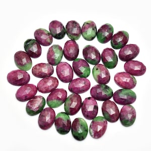 Può includere: Una collezione di 25 pietre preziose ovali sfaccettate di colore verde e rosa. Le pietre misurano circa 10 mm di lunghezza e 7 mm di larghezza.