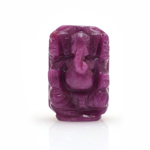 May include: A small, intricately carved statue of the Hindu deity Ganesha, made from a deep purple gemstone. The statue depicts Ganesha sitting with his trunk raised and his hands in a gesture of blessing.