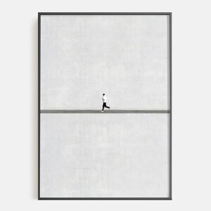 May include: Framed art print featuring a minimalist design. A small figure in black and white running across a gray line against a textured, light gray background. The artwork is encased in a black frame.