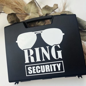 May include: Black plastic case with a white graphic of sunglasses and the text "RING SECURITY".