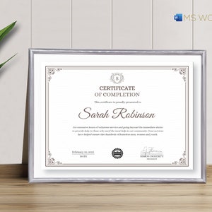 May include: A silver framed certificate of completion with a decorative border. The certificate is presented to Sarah Robinson for her outstanding service to the community. The date on the certificate is 25 February 2023.