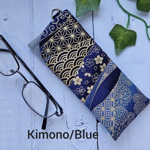 May include: A blue and gold fabric glasses case with a Japanese-inspired pattern. The case has a zipper closure and is made of a soft, durable fabric.
