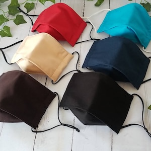 May include: Six fabric face masks in various colors, including black, brown, beige, red, blue, and navy blue. Each mask has adjustable ear loops.