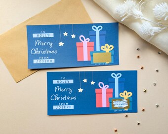 May include: Two rectangular blue Christmas gift cards featuring the text To Holly, Merry Christmas, and From Joseph. The cards display illustrations of three stacked presents with bows and hanging stars. One card has a gold scratch-off panel.
