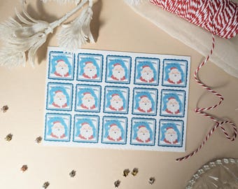 May include: A rectangular sheet of fifteen square stickers featuring a watercolor illustration of Santa Claus with a white beard and red hat against a blue background. Each sticker is bordered in blue and includes the text North Pole Mail.