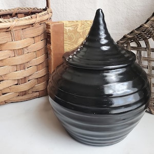 May include: A set of three ceramic nesting bowls in graduating sizes. The bowls feature a speckled, matte finish in shades of cream, light brown, and dark brown. The largest bowl is approximately 8 inches in diameter.