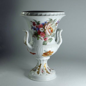 Hermoso jarrón de porcelana blanca con un brillante ramo de flores de Francia.