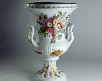 Hermoso jarrón de porcelana blanca con un brillante ramo de flores de Francia.