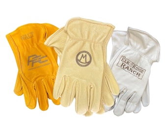 May include: Three pairs of work gloves in different colors and styles. The gloves are made of leather and have different logos printed on them. The logos include "WALT", "M", and "ELK RIDGE RANCH".