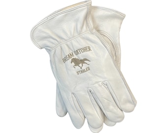 May include: White leather work gloves with the text "DREAM CATCHER STABLES" and a silhouette of a horse in gold embroidery.