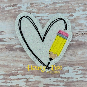 May include: A white heart-shaped felt patch with a black outline and a yellow pencil with a pink eraser inside the heart.
