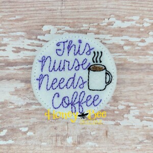 May include: Purple embroidered text on a white circle reads "This Nurse Needs Coffee" with a cartoon coffee cup and steam.