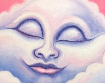Könnte beinhalten: Gerahmtes Gemälde eines lächelnden Wolkengesichts mit geschlossenen Augen. Die Wolke ist in Blau- und Weißtönen vor einem rosafarbenen Himmel gemalt. Das Kunstwerk ist rechts unten mit "Johane M." signiert. Der Rahmen ist weiß.