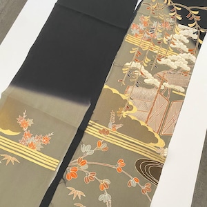 Könnte beinhalten: Zwei Stoffstücke, eines schwarz und das andere mit einem detaillierten Muster. Der gemusterte Stoff zeigt ein Landschaftsdesign mit Gebäuden, Bäumen und floralen Elementen in Gold-, Orange- und Brauntönen. Der schwarze Stoff hat einen Farbverlauf.