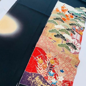 Könnte beinhalten: Ein japanischer Kimono in Schwarz und Gold mit einem farbenfrohen Blumen- und Landschaftsdesign. Das Design umfasst rote, orangefarbene und blaue Blumen, grüne Bäume und einen goldenen Hintergrund. Der Kimono hat einen Farbverlauf von Schwarz zu Creme.