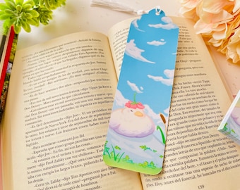 May include: A whimsical bookmark featuring a fluffy white cloud with a pink flower on top, floating in a blue sky with white clouds. The bookmark is illustrated in a cartoon style with a green grassy area at the bottom.