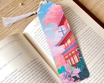 May include: A pink and blue bookmark featuring a Japanese-style building, cherry blossom trees, and a bicycle. The bookmark has a white tassel.