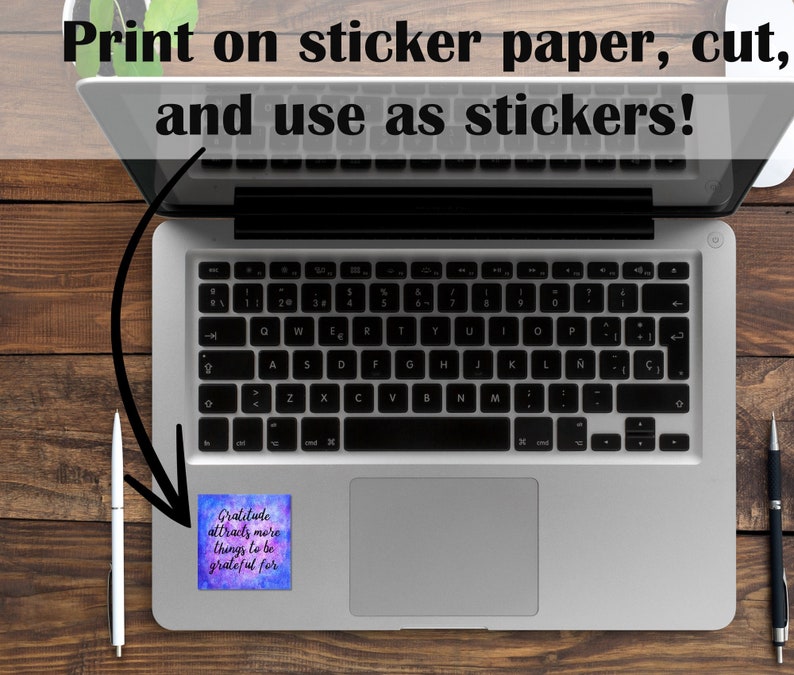 May include: A laptop computer with a sticker on the touchpad that reads "Gratitude attracts more things to be grateful for". The sticker has a watercolor background with shades of purple, blue, and pink.