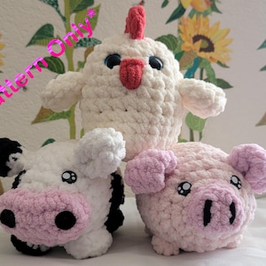 May include: Three crocheted stuffed animals: a white chicken, a black and white cow, and a pink pig. The animals are all smiling and have big eyes.