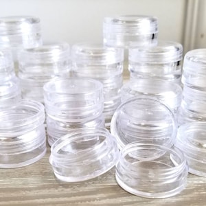 May include: A collection of clear plastic containers stacked on top of each other. The containers are various sizes and are perfect for storing small items.