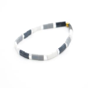 a black and white bracelet with a gold clasp














Shoreline Mix & Match Tila Bead Bracelets for Women | High Quality Stacking Bracelet | Boho Stretch Bracelet | Waterproof Miyuki Tila Beads
