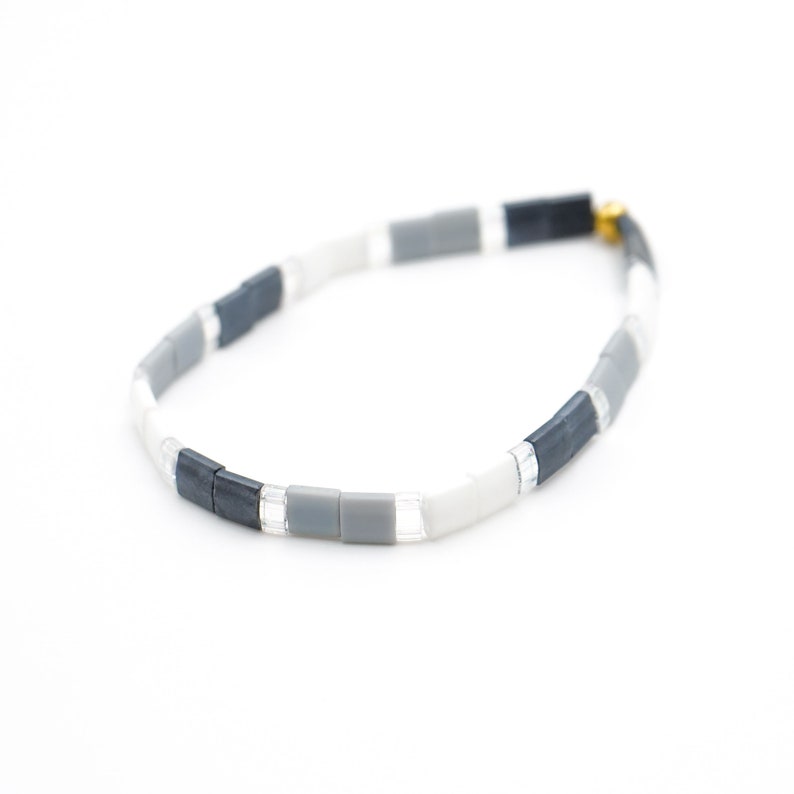 a black and white bracelet with a gold clasp














Shoreline Mix & Match Tila Bead Bracelets for Women | High Quality Stacking Bracelet | Boho Stretch Bracelet | Waterproof Miyuki Tila Beads