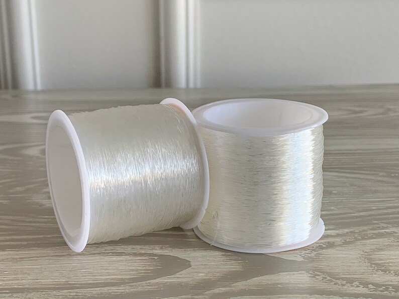 image of two 0.7mm Crystal Stretch Cord on a table. 






0.7mm Crystal Stretch Cord – 100 Meters Durable Clear Elastic String for DIY Bracelets, Jewelry Making, Beading, and Craft Projects