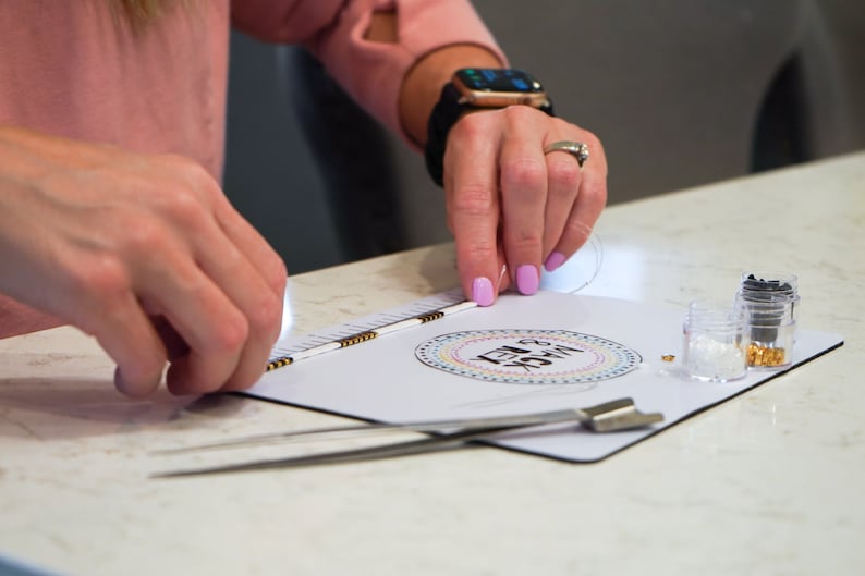image of a person measuring the length of a bracelet with the in-built measuring tape of the wipeable bead mat. 






Wipeable Bead Mat with Built-in Measuring Tape | Non-Slip Jewelry Making Tool | Perfect Beading Mat for DIY Projects