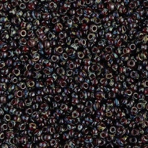 May include: A close-up view of a pile of small, round beads. The beads are primarily dark in color, with a mix of deep reds, blacks, and hints of blue. Each bead has a small hole running through the center.