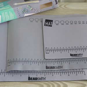May include: Three gray beading mats with black markings and the text "Beadsmith" and "Treasure Mat". The mats have rulers in inches and centimeters, and circles for measuring bead sizes.