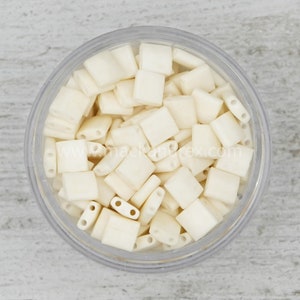 a bowl filled with white plastic beads on top of a table