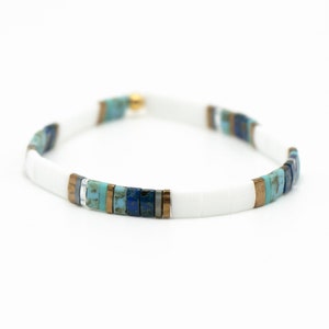 a white bracelet with blue and brown beads