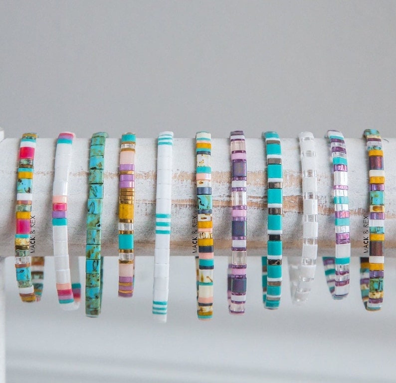 a bunch of bracelets that are sitting on a piece of wood