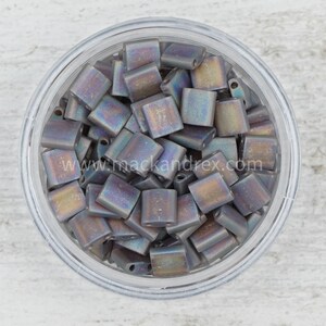 May include: A clear glass jar filled with iridescent gray square beads. The beads have a metallic sheen and are approximately 4mm in size.